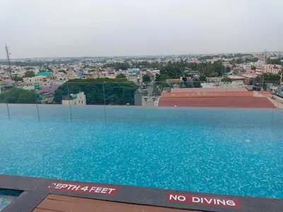a large swimming pool with a city in the background at Fortune Park, Tiruppur - Member ITC Hotels' Group in Tiruppūr