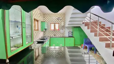 a kitchen with green cabinets and a staircase at La Flora kodaikanal in Kodaikānāl