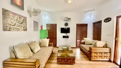 a living room with two couches and a table at La Flora kodaikanal in Kodaikānāl