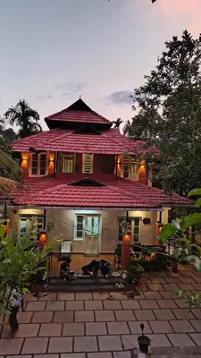 a large house with a patio in front of it at Nostalgia Homestay in Vythiri