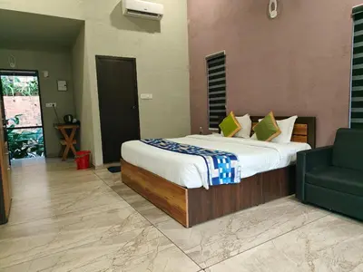 a bedroom with a large bed and a green chair at Safari Hills in Vayittiri