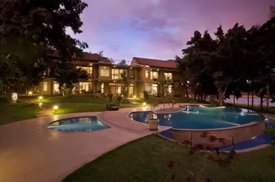 an exterior view of a resort with two pools at Waterwoods Lodge Kabini in Begūr