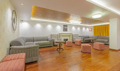 a waiting room with couches and tables and a fireplace at Treebo Windsor Heights, 8 Mins To Ketti Valley View Point in Ooty