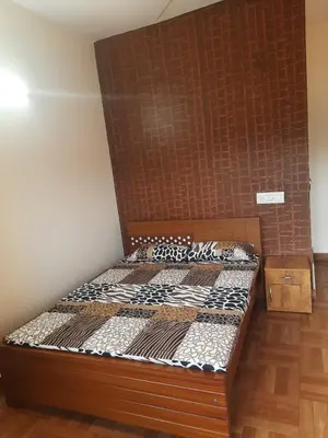 a bed in a room with a brick wall at Paadi Inn in Kakkabe
