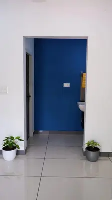 a blue door in a room with two potted plants at WAYANAD OASIS VILLa in Kalpetta