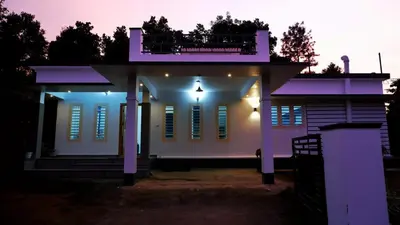 a white house with a balcony on top of it at WAYANAD OASIS VILLa in Kalpetta