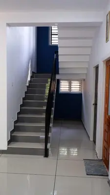 a hallway with stairs in a house with blue walls at WAYANAD OASIS VILLa in Kalpetta