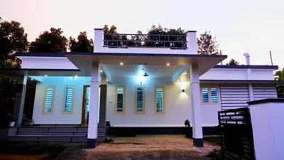 a white house with a balcony on top of it at WAYANAD OASIS VILLa in Kalpetta