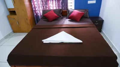 two beds with red pillows and a white napkin on them at WAYANAD OASIS VILLa in Kalpetta