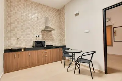 a kitchen with a table and chairs and a mirror at Corner Stay Serviced Apartment-Racecourse in Coimbatore