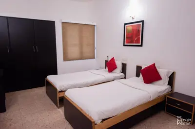 two beds in a room with red pillows at Corner Stay Serviced Apartment-Racecourse in Coimbatore
