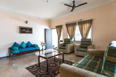 a living room with a blue couch and chairs at Corner Stay Serviced Apartment-Racecourse in Coimbatore