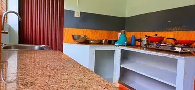 a kitchen with a counter top with pots and pans at Kalpetta Peace Villa in Kalpetta