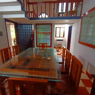 a dining room with a glass table and chairs at Kalpetta Peace Villa in Kalpetta