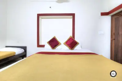a bedroom with a large bed with two pillows at Coorg Avani Holiday Inn in Madikeri