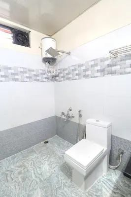 a bathroom with a toilet and a sink at Coorg Avani Holiday Inn in Madikeri
