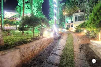 a stone path in a park at night at Coorg Avani Holiday Inn in Madikeri