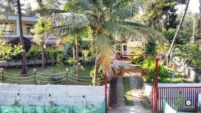 a palm tree in front of a building at Coorg Avani Holiday Inn in Madikeri
