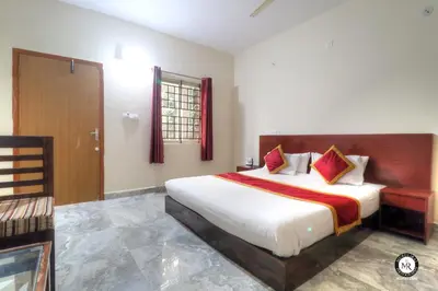 a bedroom with a large bed and a window at Coorg Avani Holiday Inn in Madikeri