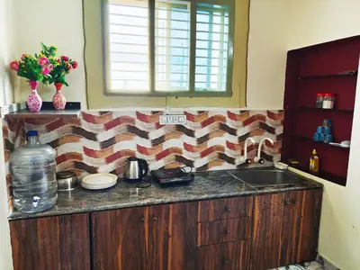 a kitchen with a counter with a sink and a window at Mannat Inn (Peace Homestay) in Mysore