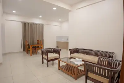a living room with a couch and chairs and a table at Daffodils Luxury Airport Suites in Cochin