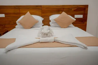 a towel animal is sitting on a bed at Daffodils Luxury Airport Suites in Cochin