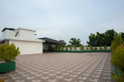 a courtyard with a white building and some plants at Daffodils Luxury Airport Suites in Cochin