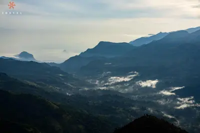 a view of a valley with mountains in the distance at Zostel Plus Poombarai, Kodaikanal in Kodaikānāl