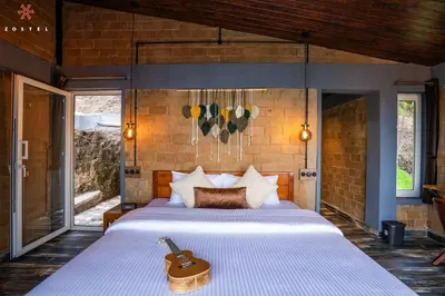 a bedroom with a large white bed in a room at Zostel Plus Poombarai, Kodaikanal in Kodaikānāl