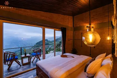 a bedroom with a bed and a large window at Zostel Plus Poombarai, Kodaikanal in Kodaikānāl