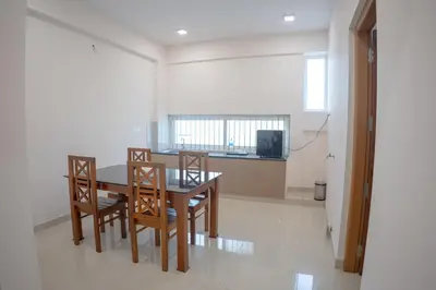 a dining room with a table and chairs at Daffodils Luxury Airport Suites in Angamali