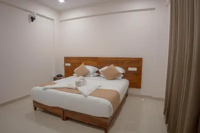 a bedroom with a large bed with a wooden headboard at Daffodils Luxury Airport Suites in Angamali