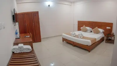 a bedroom with a large bed in a room at Daffodils Luxury Airport Suites in Angamali