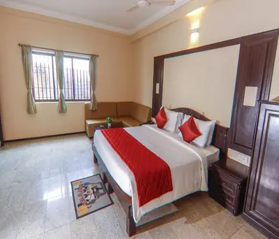 a bedroom with a large bed with red pillows at Hotel Vinayaga Excellenciy Tiruppur in Tiruppūr