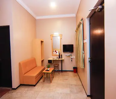 a living room with a chair and a table at Hotel Vinayaga Excellenciy Tiruppur in Tiruppūr