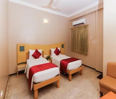 a hotel room with two beds and a couch at Hotel Vinayaga Excellenciy Tiruppur in Tiruppūr
