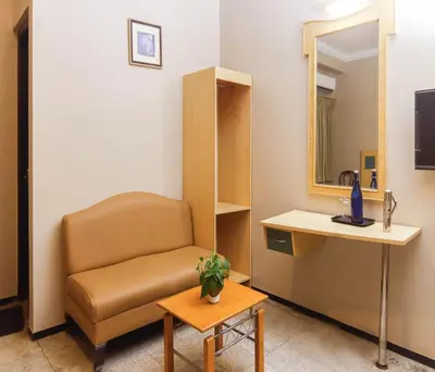 a waiting room with a chair and a table at Hotel Vinayaga Excellenciy Tiruppur in Tiruppūr