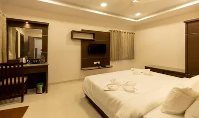 a bedroom with a large white bed and a television at The Bee Hives , Nectar Nest in Coimbatore