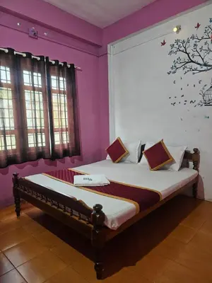 a bed in a room with purple walls and windows at Cicily Cottage in Munnar