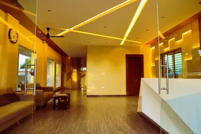a lobby with yellow walls and a couch and a table at ELITE RESIDENCY in Palani