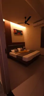 a bedroom with a bed with a ceiling fan at ELITE RESIDENCY in Palani