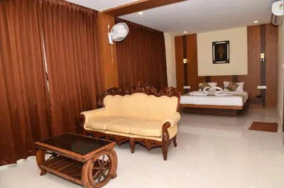 a living room with a couch and a bed at Sanjose Residency in Virajpet