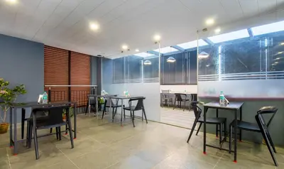 a restaurant with tables and chairs in a room at Treebo Brahma, Wayanad in Sultan Bathery