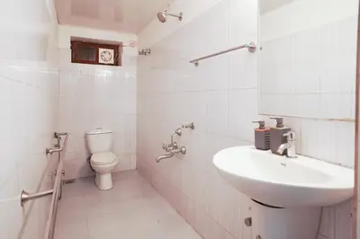 a white bathroom with a sink and a toilet at Wayanad Palm Grove Retreat G Floor in Sultan Bathery