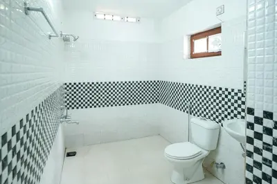 a white bathroom with a toilet and a sink at Wayanad Palm Grove Retreat G Floor in Sultan Bathery