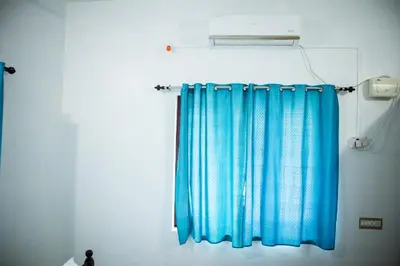 a blue curtain in a room with a light at Padmanabhan's Homestay in Thrissur, Punkunnam in Trichūr