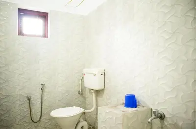 a bathroom with a white toilet in a room at Padmanabhan's Homestay in Thrissur, Punkunnam in Trichūr