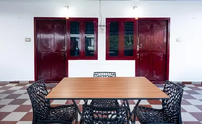 a wooden table and chairs in a room at Padmanabhan's Homestay in Thrissur, Punkunnam in Trichūr