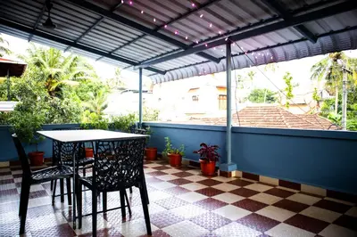 a patio with a table and chairs on a checkered floor at Padmanabhan's Homestay in Thrissur, Punkunnam in Trichūr