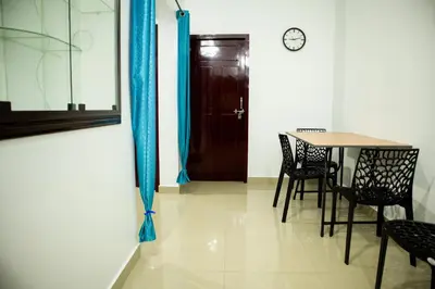 a dining room with a table and chairs and a door at Padmanabhan's Homestay in Thrissur, Punkunnam in Trichūr